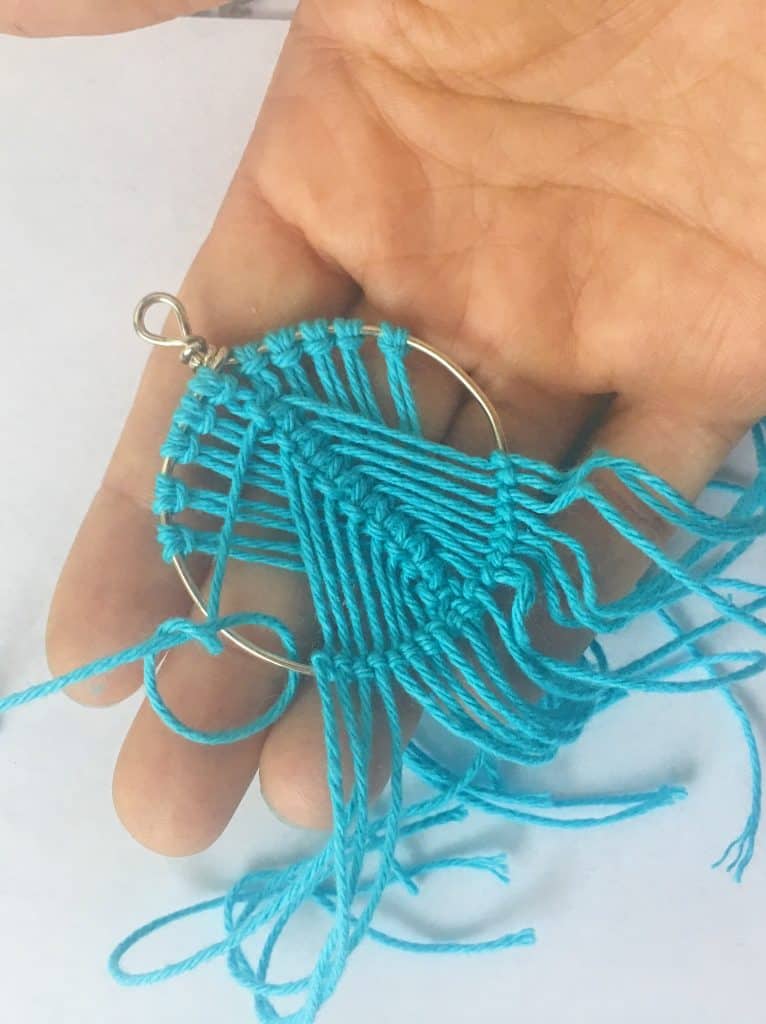 secure strings with knot at bottom of frame